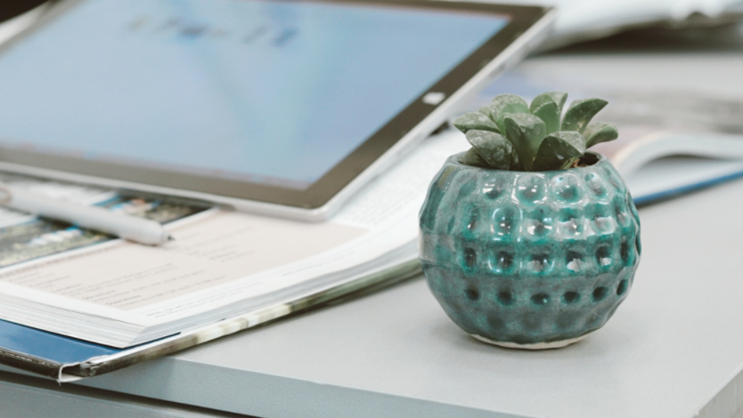 Teal planter sitting next to a computer