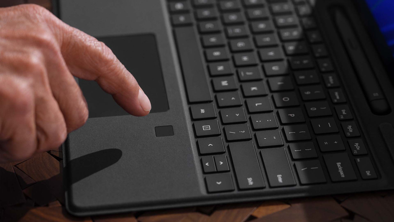 إصبع شخص يؤشر فوق ميزة تسجيل الدخول البيومتري في جهاز Surface Pro Signature Keyboard لوحة مفاتيح‎