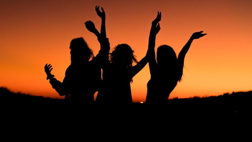 Three people partying at sunset