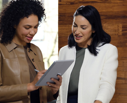 Dva kolegové spolupracují v kanceláři pomocí zařízení Surface Go 3