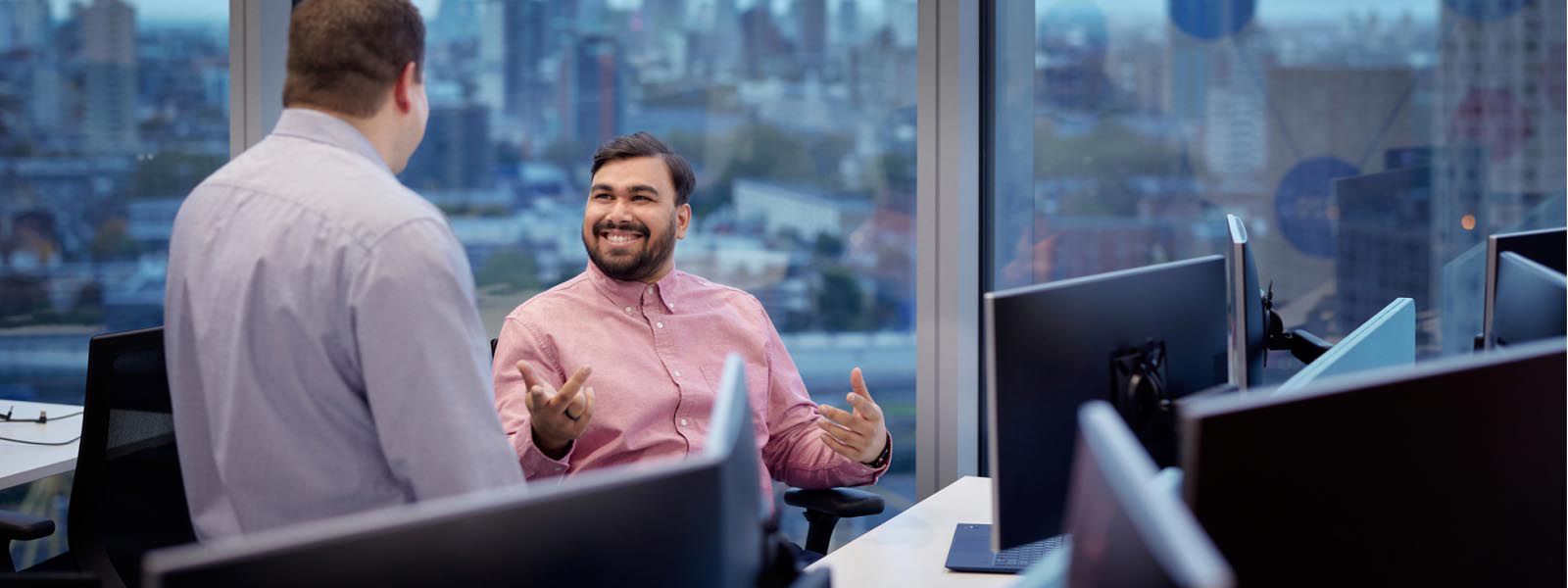 Two co-workers in front of Microsoft devices