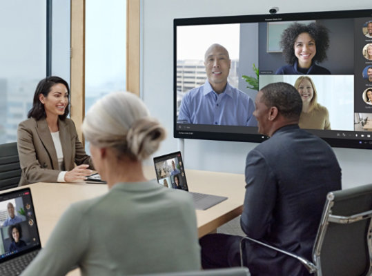 Zwei Gruppen interagieren Rahmen eines Teams-Anrufs. Ein Team ist virtuell dabei, während das andere Team vor Ort ist.