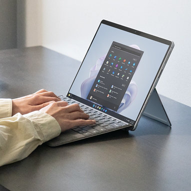 Two hands use a Surface Pro Signature Keyboard to type using a Surface Pro 9