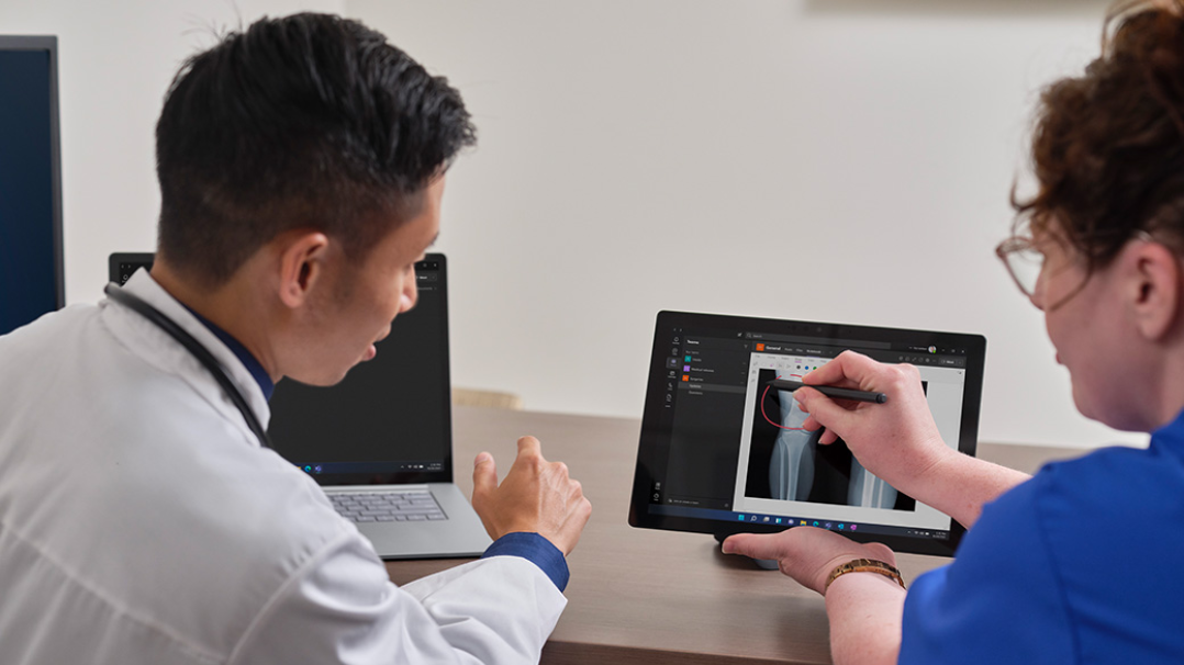 Two medical professionals analyze the findings on an X-Ray