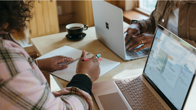 Two people using Surface devices at a table