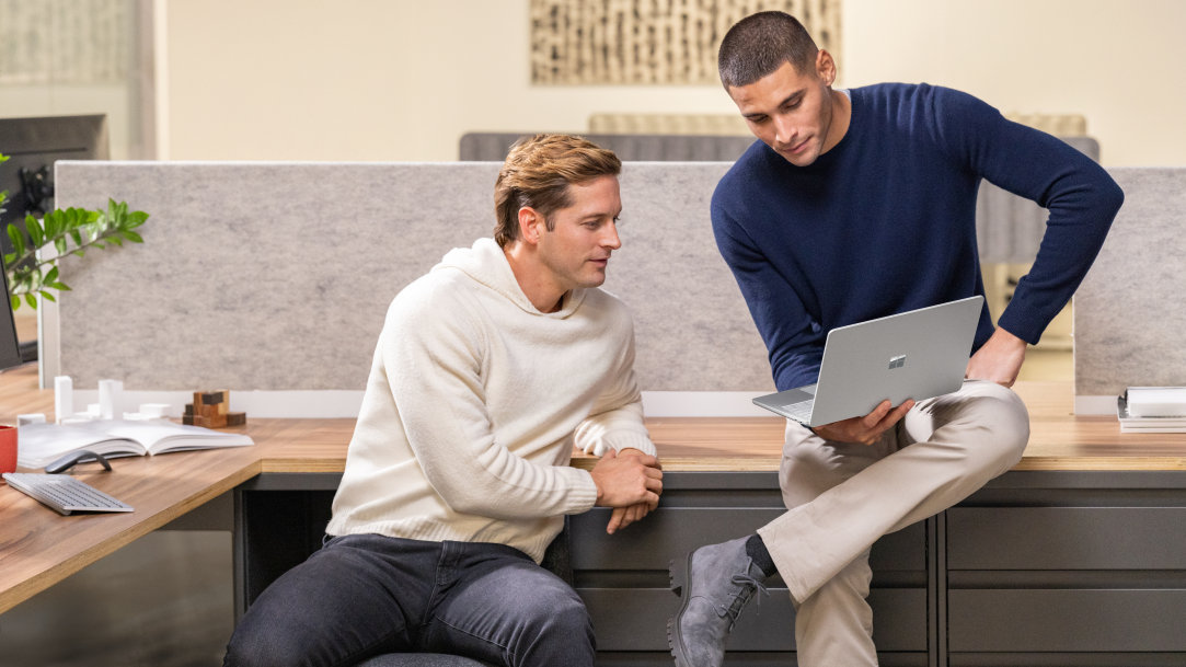 Two women collaborating on a Microsoft Surface laptop