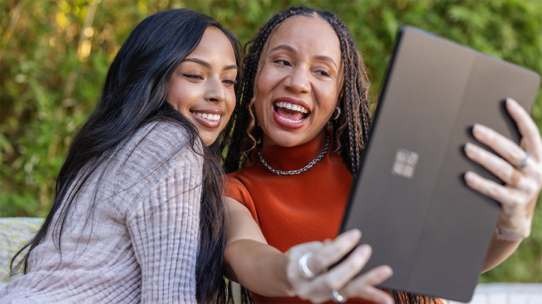 Two women looking at their Surface laptop exploring Windows AI features