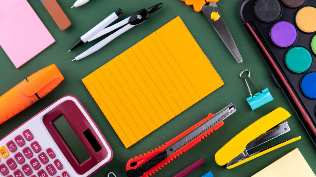 Various office supplies neatly arranged on a green surface