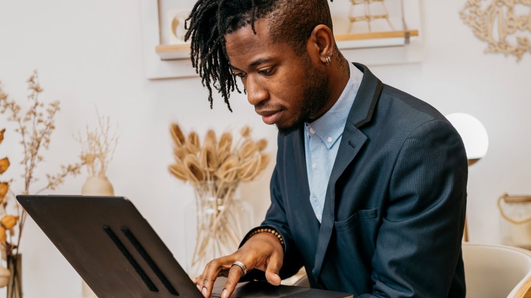 A man in an office on a video call with a laptop