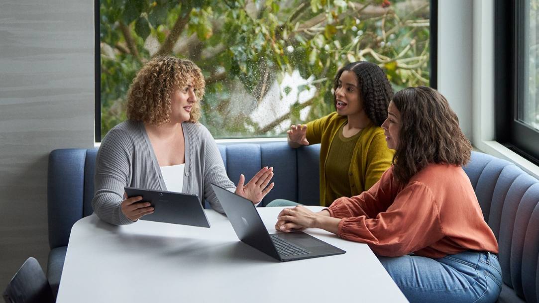A group of coworkers collaborate in an office space around a computer