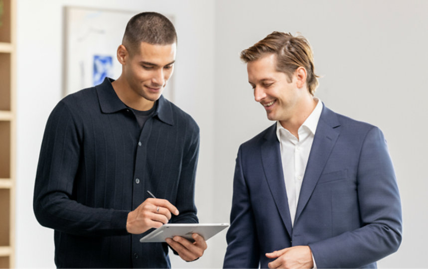 Two coworkers look at the screen of a Windows device