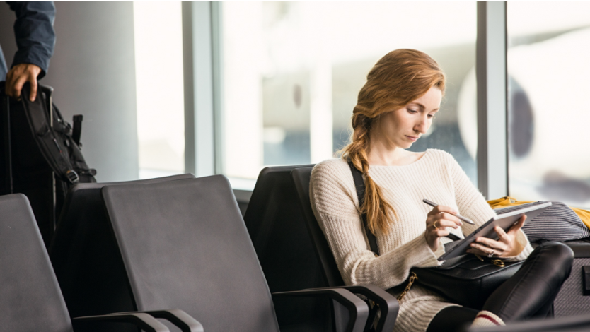Woman at the airport using Surface device and pen