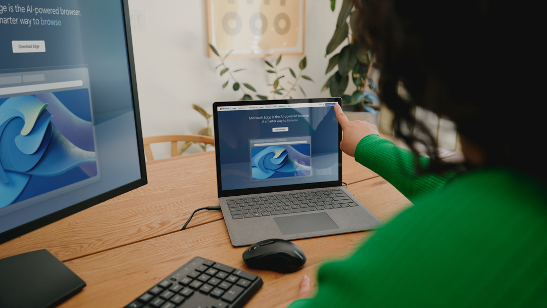 Woman browsing on a Surface 2-in-1 laptop