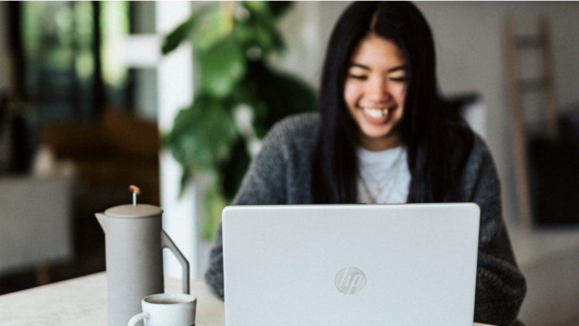 Woman in gray sweater using laptop