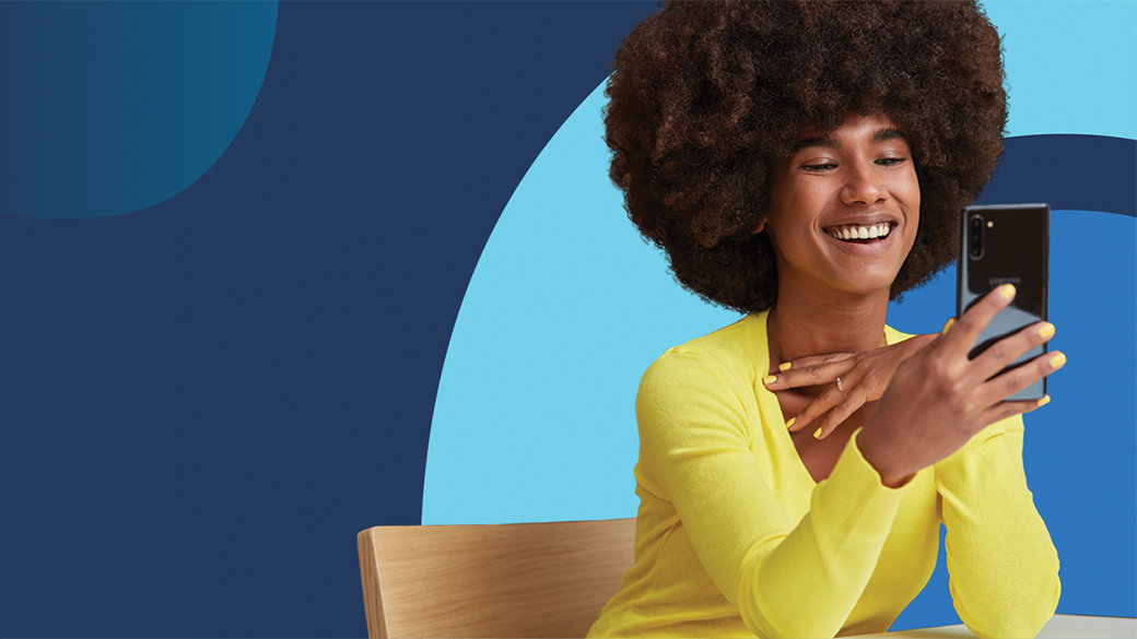 Woman in yellow shirt looking at her mobile phone