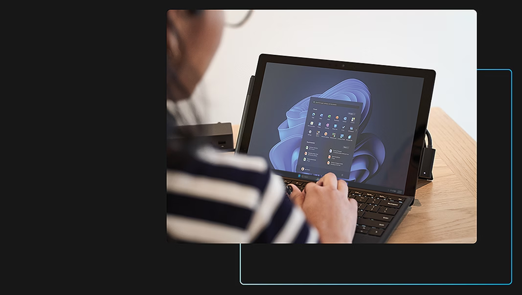 一位女士坐在笔记本电脑前工作的背影，电脑屏幕显示启动画面。