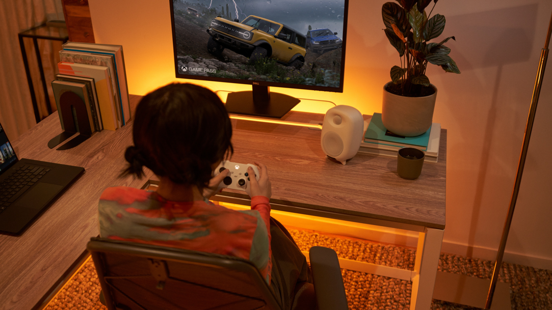 Woman playing a driving PC game at a desk