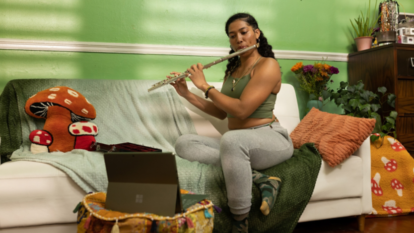 Woman playing a flute in front of a Surface device