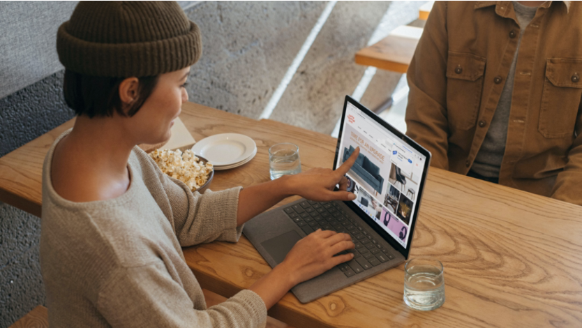 Woman points to her laptop screen while online shopping 