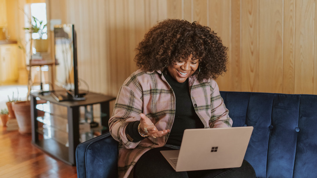 Woman sitting on a couch looking at her computer