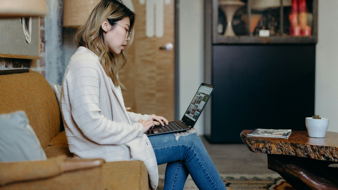 Woman sitting on a couch with her laptop