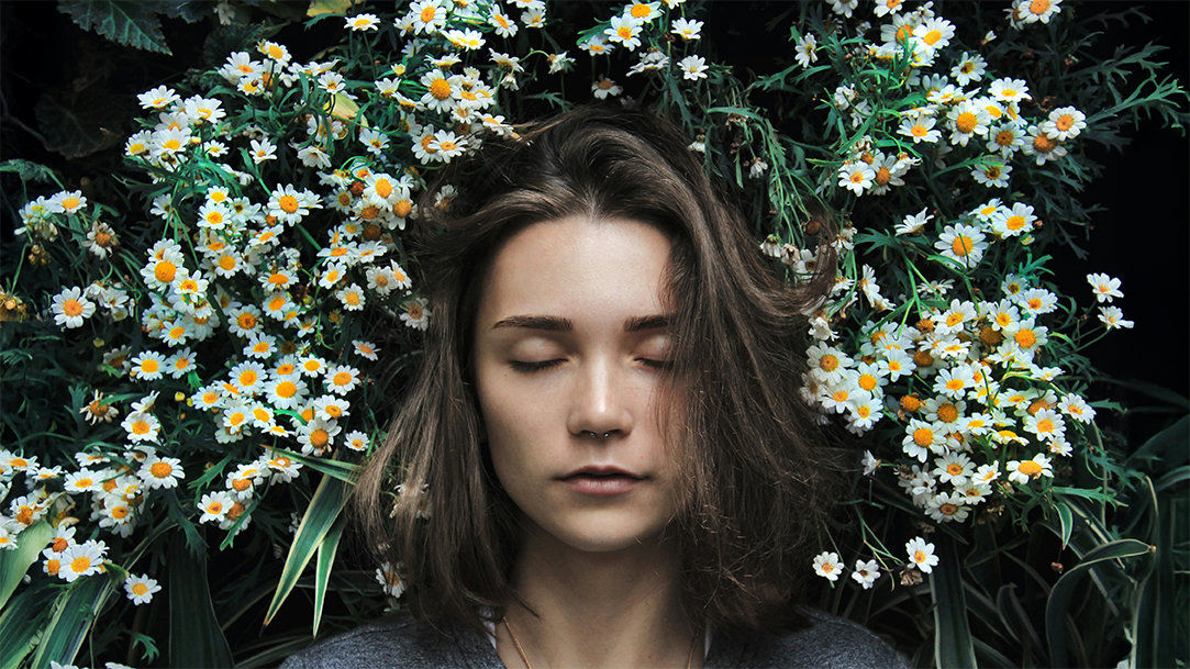 Woman sleeping peacefully in a bed of flowers