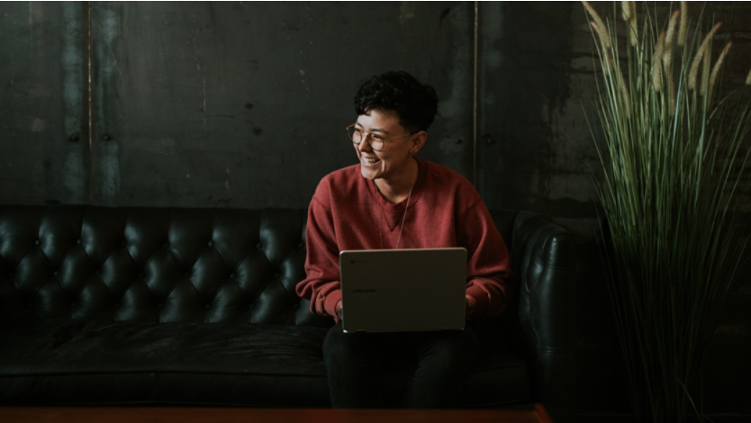 Woman smiling and working on a laptop