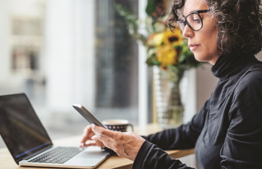 Woman syncing phone and  computer