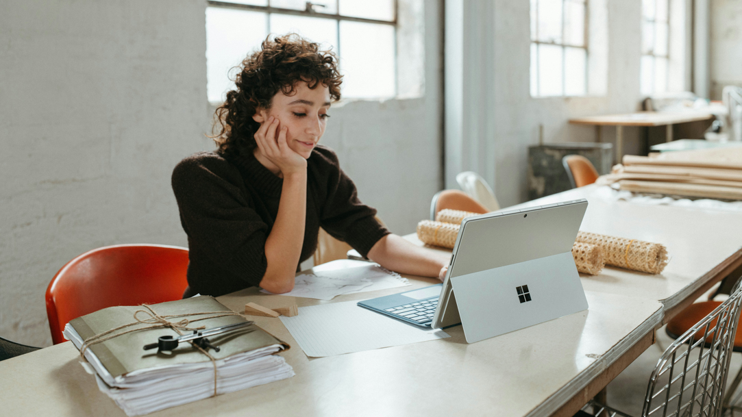 Woman using Microsoft Surface laptop at table