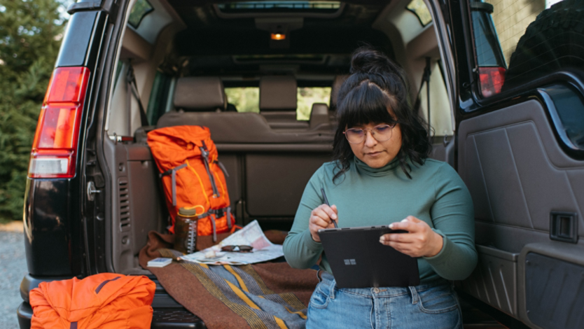 Woman using Surface tablet in back of SUV