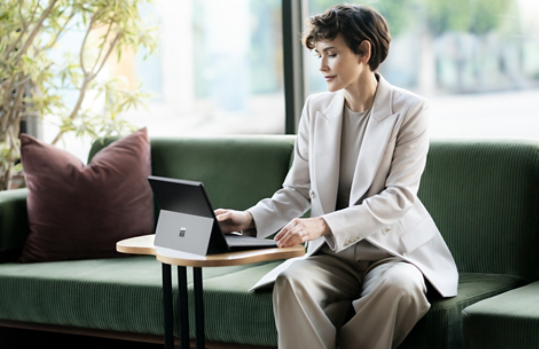 Woman using a Surface Pro 10 while sitting in a lobby chair