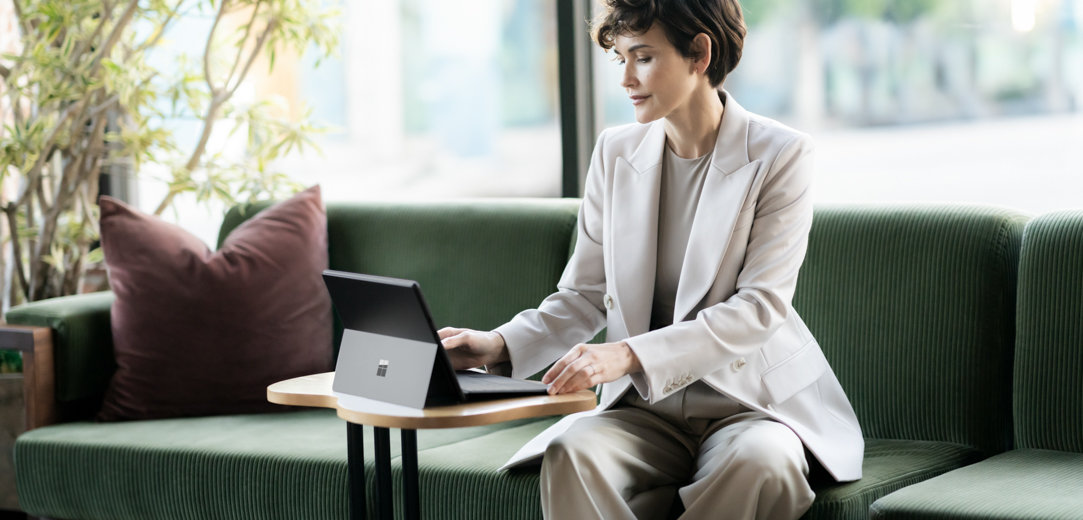 Woman using a Surface Pro 10 while sitting in a lobby chair