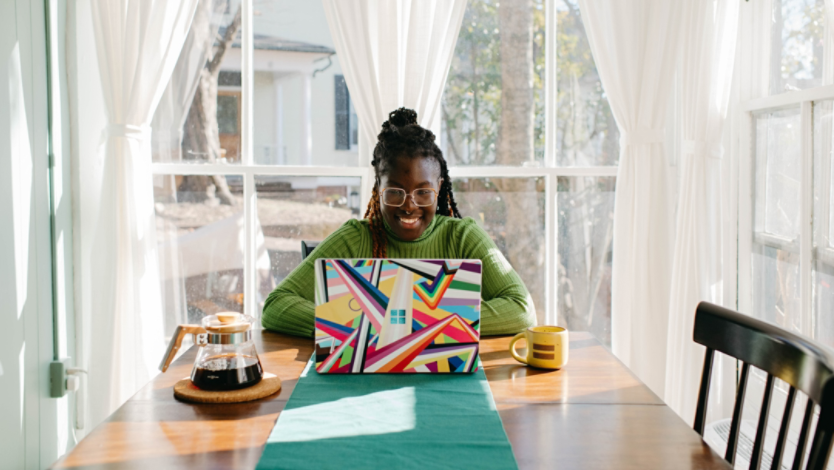 A person using a Surface laptop at a kitchen table