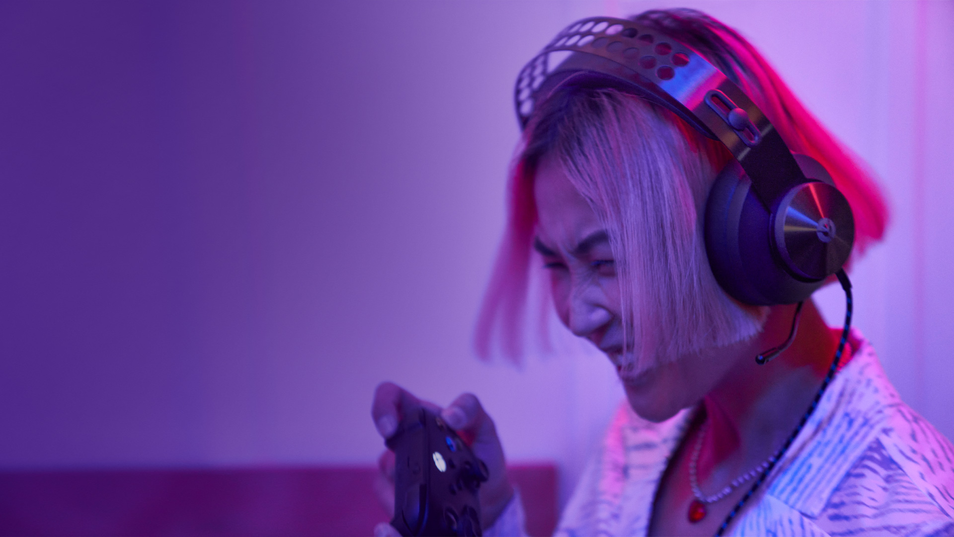 Kobieta ze słuchawkami na głowie trzymająca kontroler do gier