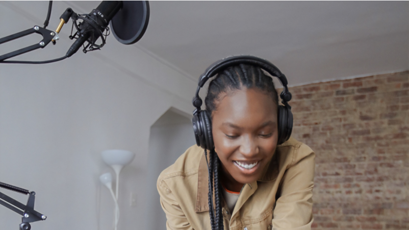 Woman with headphones and mic set using a Surface laptop