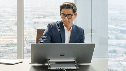 Un homme utilise un Surface Studio 2+ en position inclinée pour une utilisation plus facile de l’écran tactile.