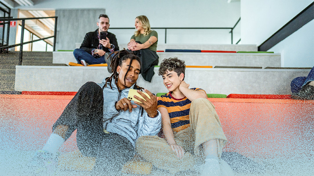Young students friends talking and using mobile phone at auditorium