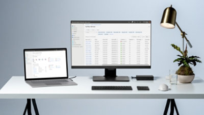 a Microsoft Surface Laptop on a modern desk with a monitor, keyboard, and wireless mouse