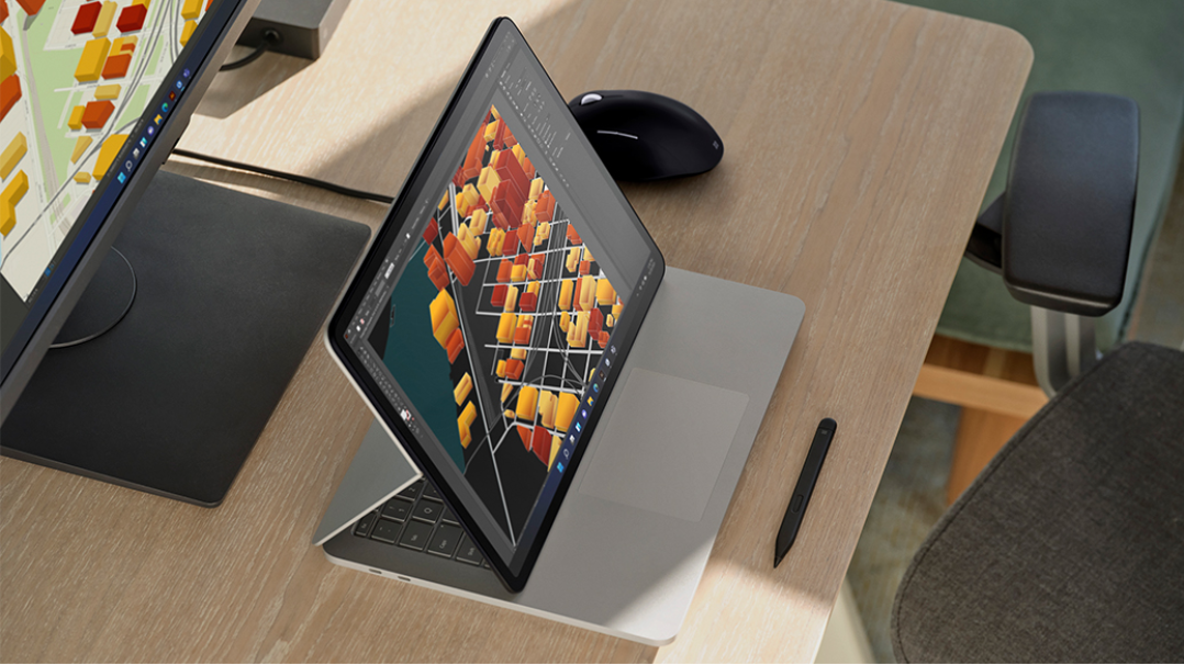 En Surface Book ses stå på et skrivebord i et produktionsmiljø