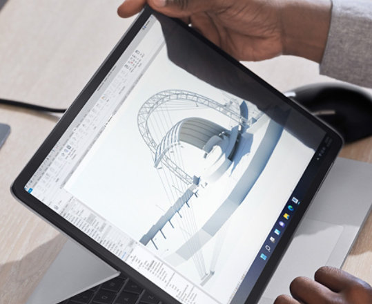 Urządzenie Surface Laptop Studio widziane w trybie scenicznym na biurku w domowym biurze