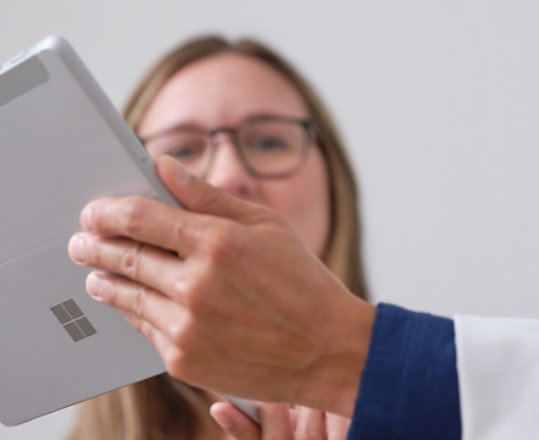 Lékař ukazuje pacientovi léčebný plán na zařízení Surface Pro