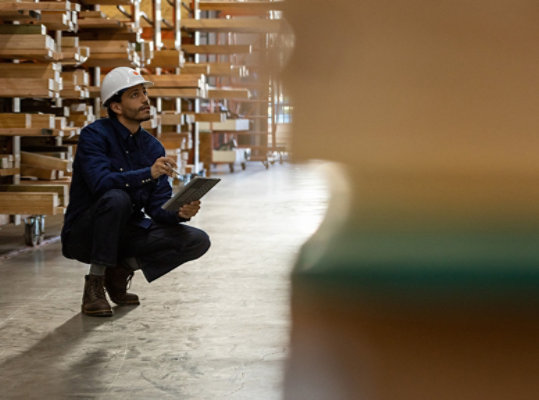 Un homme se penche dans un entrepôt pour inspecter le contenu d’une étagère