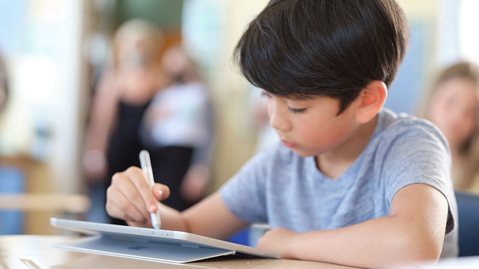 Uczeń używający pióra Surface do pisania na urządzeniu Surface Go