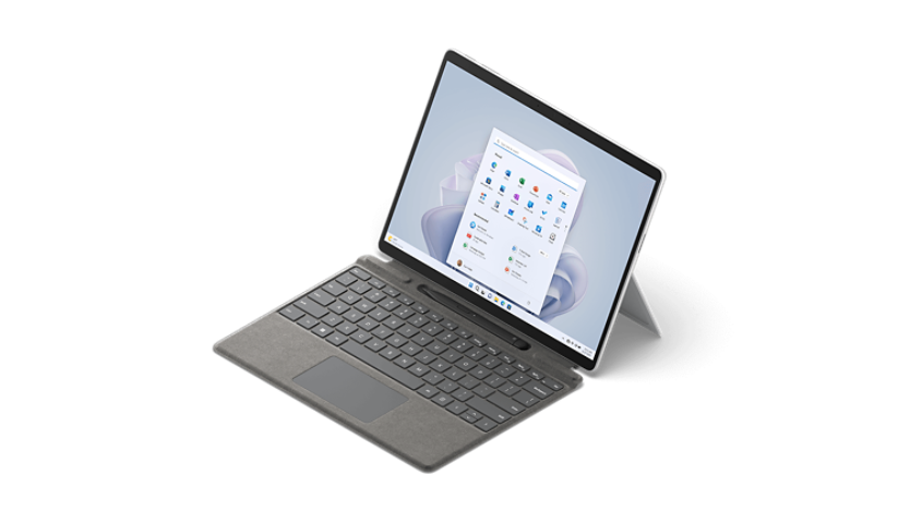 Surface Pro 9 shown from a 3/4 view with attached type cover and Surface Slim Pen 2.
