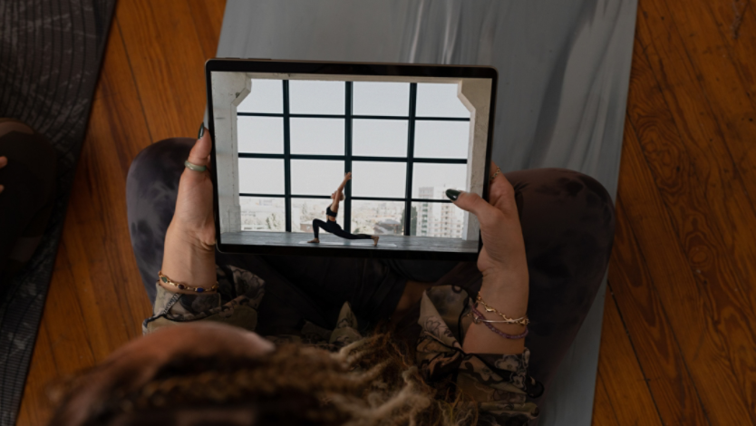 a woman holding up a tablet with a picture of a woman on it