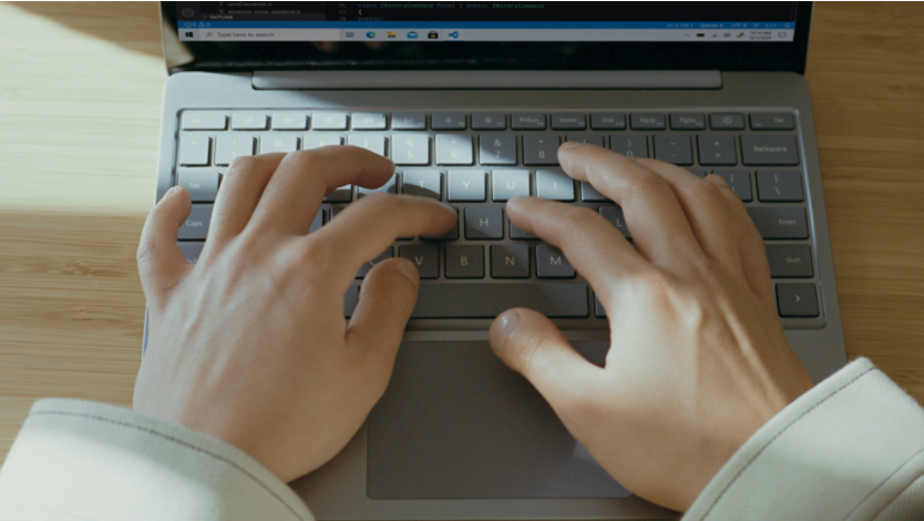 Computer science student codes using a Surface laptop