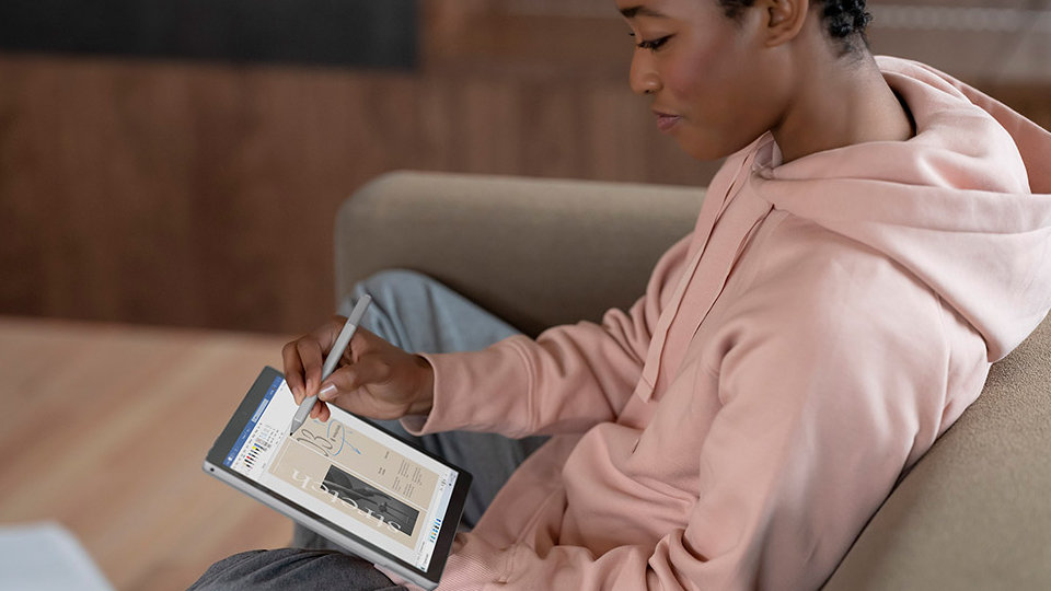 A person using Surface Pro 7+ as a tablet with Surface Pen.