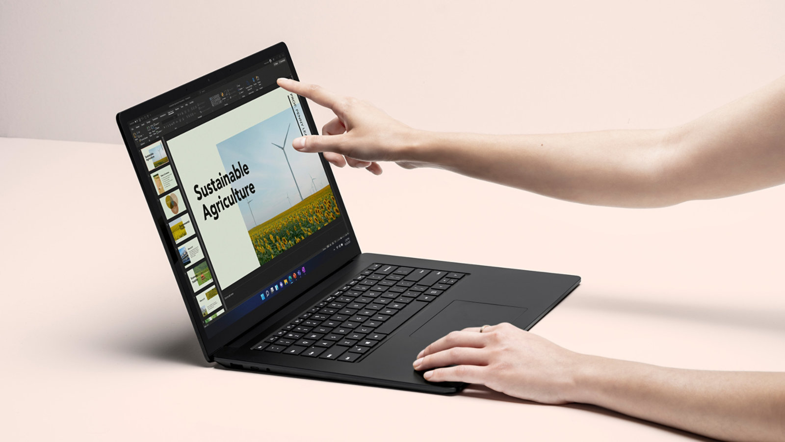 A person’s hands are shown interacting with the touchscreen on Surface Laptop 4