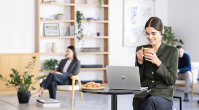 在咖啡店使用 Surface Laptop 的人