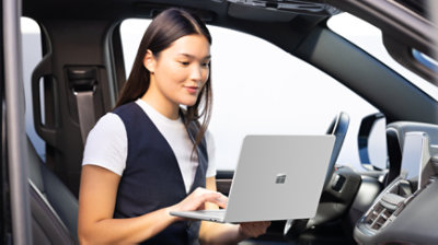 在车内使用 Surface Laptop 的人